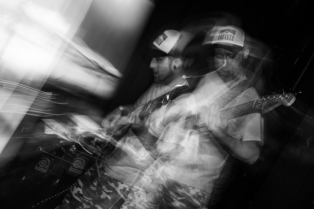 A man superimposed strumming an electric guitar