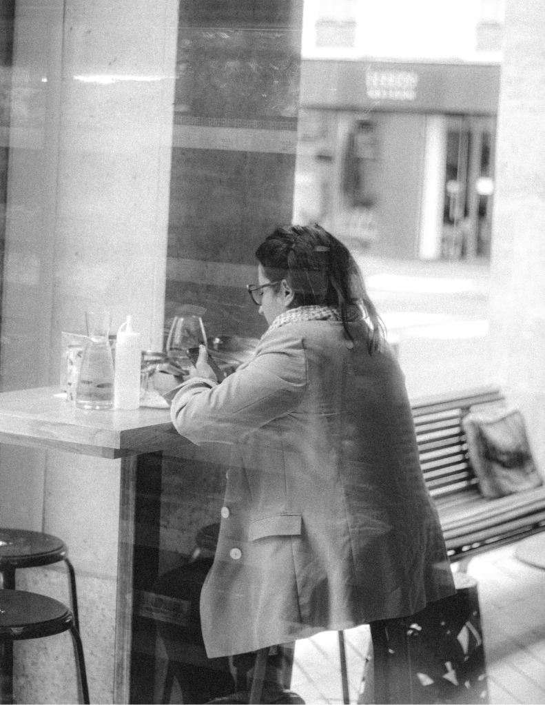 Anonymous woman chatting on smartphone in cafe
